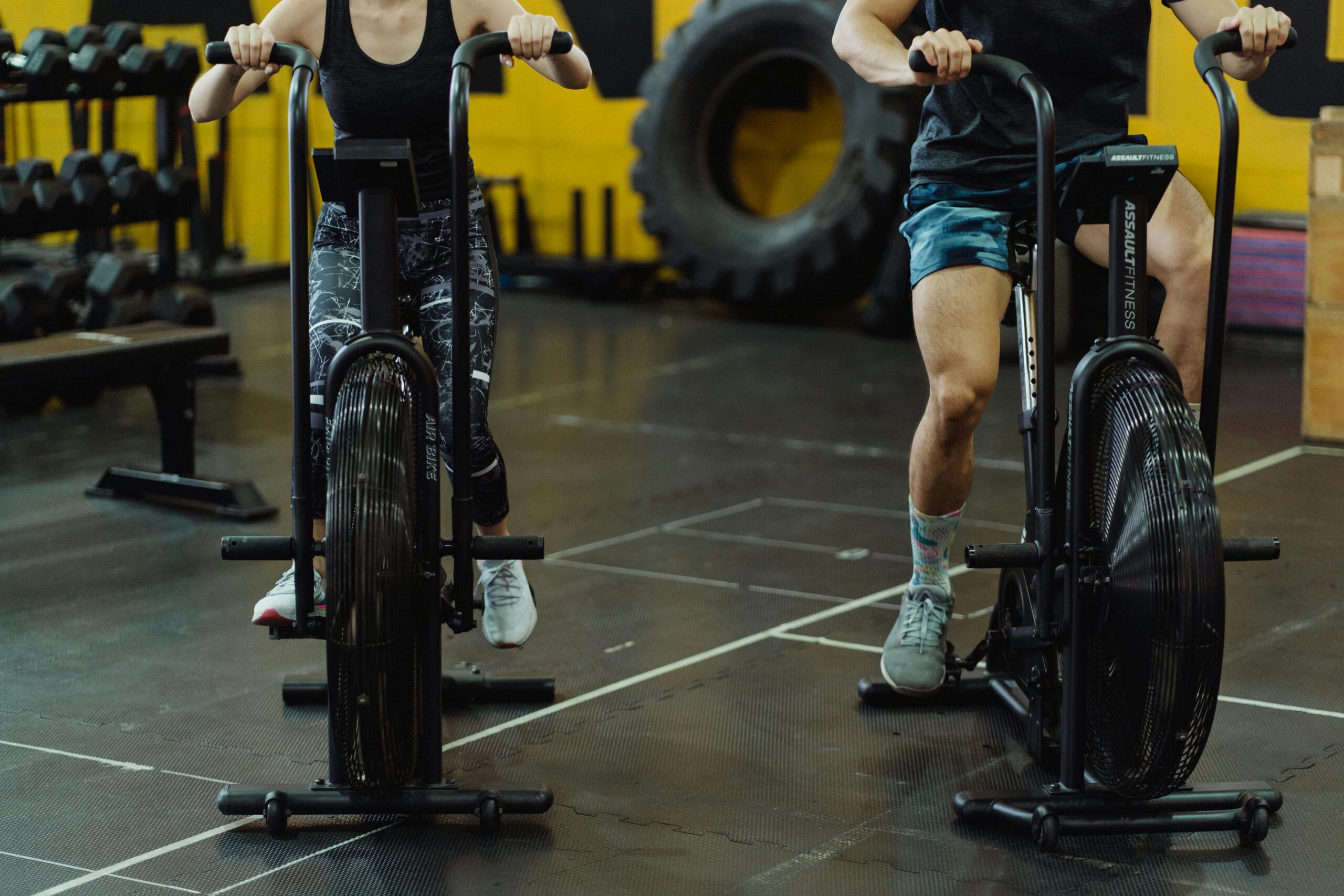 Two people exercising on stationary bikes at a modern gym.